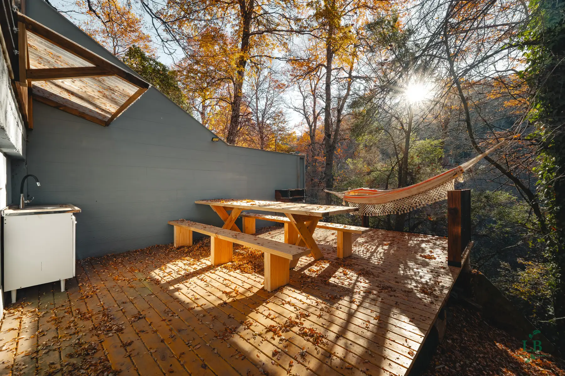 Deck con hamaca paraguaya entre los árboles